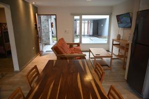 Una sala de estar con una mesa y sillas de madera. en Costa Azul Rent Apartments, en Costa Azul