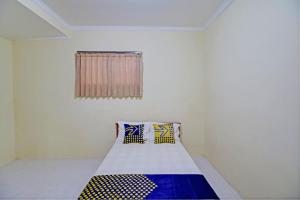 Habitación con cama con 2 almohadas en OYO Life 92953 Nirmala Kost, en Singaraja