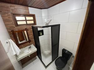 a bathroom with a shower and a toilet and a sink at Pousada Oceano Atlântico in Marau