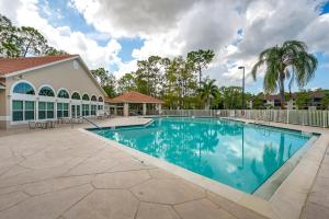 a swimming pool in the courtyard of a villa at Naples Condo with Pool Access - 3 Mi to Beaches! in Naples