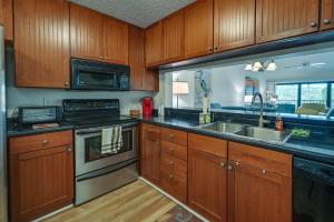 a kitchen with wooden cabinets and stainless steel appliances at Naples Condo with Pool Access - 3 Mi to Beaches! in Naples
