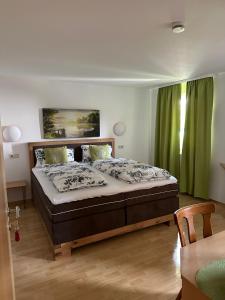 a bedroom with a large bed with green curtains at Gasthaus zu den 7 Winden in Spaichingen