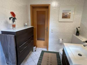 ein Bad mit einem Waschbecken, einem WC und einem Schrank in der Unterkunft Appartement Am Weinberg in Radebeul