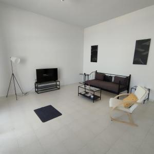 uma sala de estar com um sofá e uma televisão em STUDIOS POSEIDONIA apartments 50 & 70 sqm with sea view em Corinto