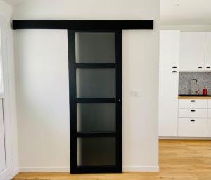 une chambre avec une porte en verre dans une cuisine dans l'établissement La p'tite Nouba à 300m de la mer, à Cayeux-sur-Mer