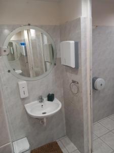 a bathroom with a sink and a mirror at House marios airport in Spata