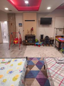 a living room with a play room with a fire place at House marios airport in Spata