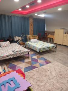 a room with two beds and two tables in it at House marios airport in Spata