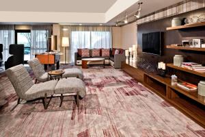 un soggiorno con divano, sedie e TV di Courtyard by Marriott Charlotte Ballantyne a Charlotte