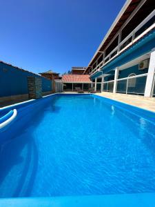 卡波布里奧的住宿－Pousada Florestinha，一座大型蓝色游泳池,位于大楼旁边