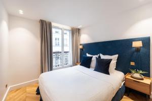 a bedroom with a large bed and a window at Quartier Libre - Saint Georges in Paris