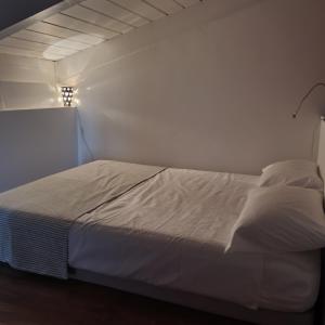 a white bed in a room with a white wall at Gaia Suites in Turin