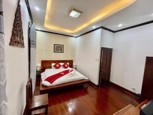 a bedroom with a bed with red pillows on it at Villa Phathana Boutique Hotel in Luang Prabang