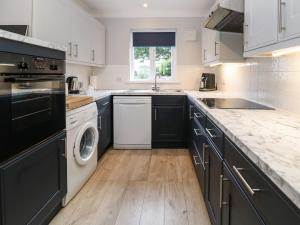 a kitchen with black and white appliances and a sink at Primrose Cottage in Falmouth