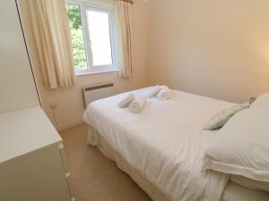 a bedroom with two white towels on a bed at Primrose Cottage in Falmouth