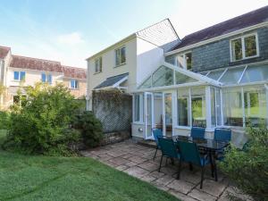 a house with a patio with a table and chairs at Primrose Cottage in Falmouth