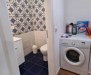 a bathroom with a washing machine and a toilet at Art House Funchalet in Funchal