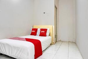 1 dormitorio con 1 cama con 2 almohadas rojas en OYO Life 92684 Kost Mutiara Nirwana, 