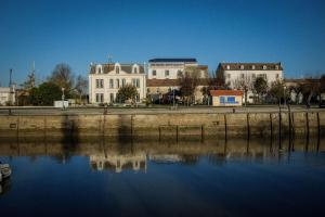 a group of buildings next to a body of water at Le Domaine du Meunier in Mortagne-sur-Gironde