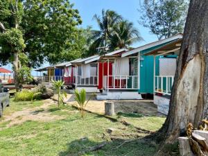 a row of colorful houses with a tree at Global Star Chalet in Kampong Batang Tiga