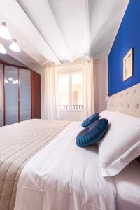 uma cama com duas almofadas azuis em cima em Maison Indipendenza em Bolonha