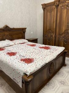 Un dormitorio con una cama con flores rojas. en Lovely home en Urganch