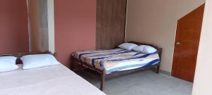 two beds in a small room with two pillows at Villa Potokar in Tingo María