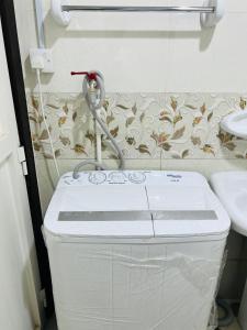 a washing machine in a bathroom with a sink at Cozy Studio Apartment 2 in Dubai