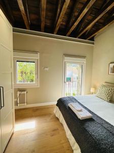 Un dormitorio con una cama grande y una ventana en La Casita de Lauri, en El Escorial