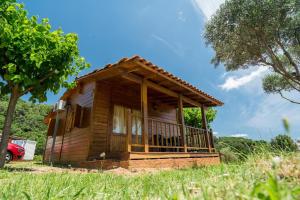 una pequeña casa de madera en un campo de hierba en Camping El Pasqualet en Caldes de Montbui