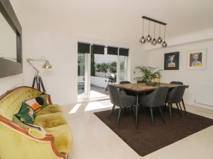 a living room with a dining room table and a couch at Brompton Gardens in Torquay