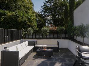 a patio with two white couches and a table at Brompton Gardens in Torquay