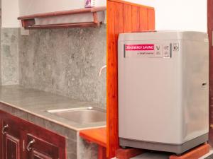a kitchen with a sink and a small refrigerator at Kurumi Capsule Hotel in Weligama