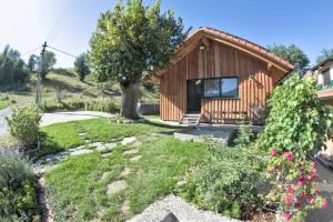 ein kleines Holzhaus mit einem Baum im Hof in der Unterkunft Holzhäuschen mit Pool 