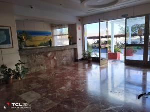 an empty lobby with a large glass door and potted plants at Casa Maya in Maspalomas