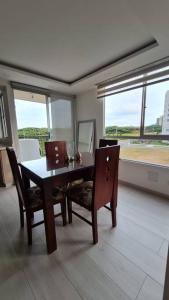 a dining room with a table and chairs and a window at Apartamento en Guabinas Yumbo 