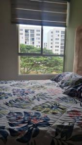 a bedroom with a bed and a window with a view at Apartamento en Guabinas Yumbo 