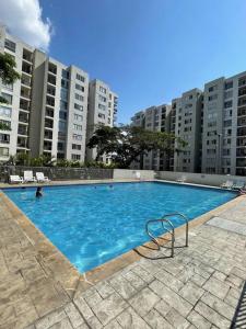 a large swimming pool in front of tall buildings at Apartamento en Guabinas Yumbo 