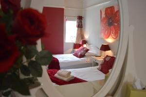 a reflection of a bedroom with two beds in a mirror at Witchingham B&B in Holyhead
