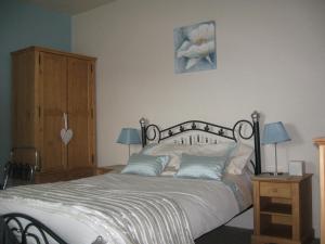 a bedroom with a bed and a wooden cabinet at Witchingham B&B in Holyhead