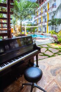a piano and a stool next to a pool at Canary Nungwi Hotel & SPA in Nungwi
