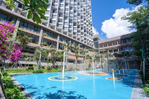 a large pool in front of a tall building at Apec Nirvana Peace Mui Ne in Mui Ne