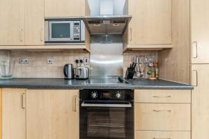 a kitchen with a stove and a microwave at Pass the Keys - Modern and cosy flat in the hart of Central London in London