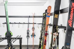 ビエラにあるRiu Nere Mountain Apartmentsのスキーやスノーボードの数々が壁に寄りかかっています