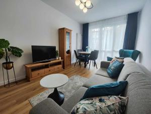 een woonkamer met een bank, een tv en een tafel bij Centrum Miasta in Stargard