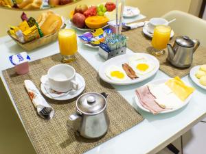 a breakfast table with eggs and bread and fruit at Condor Hotel in Rio de Janeiro