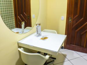 bagno con tavolo bianco e specchio di Condor Hotel a Rio de Janeiro