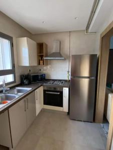 a kitchen with a stainless steel refrigerator and a sink at Dar Kmar in Tunis