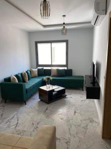 a living room with a green couch and a television at Dar Kmar in Tunis