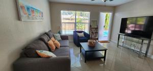 a living room with a couch and a tv at Prime Location-Equipped House W Pool & Patios, Near the Beaches, Ideal for Small Families, Coastal Haven in Fort Lauderdale